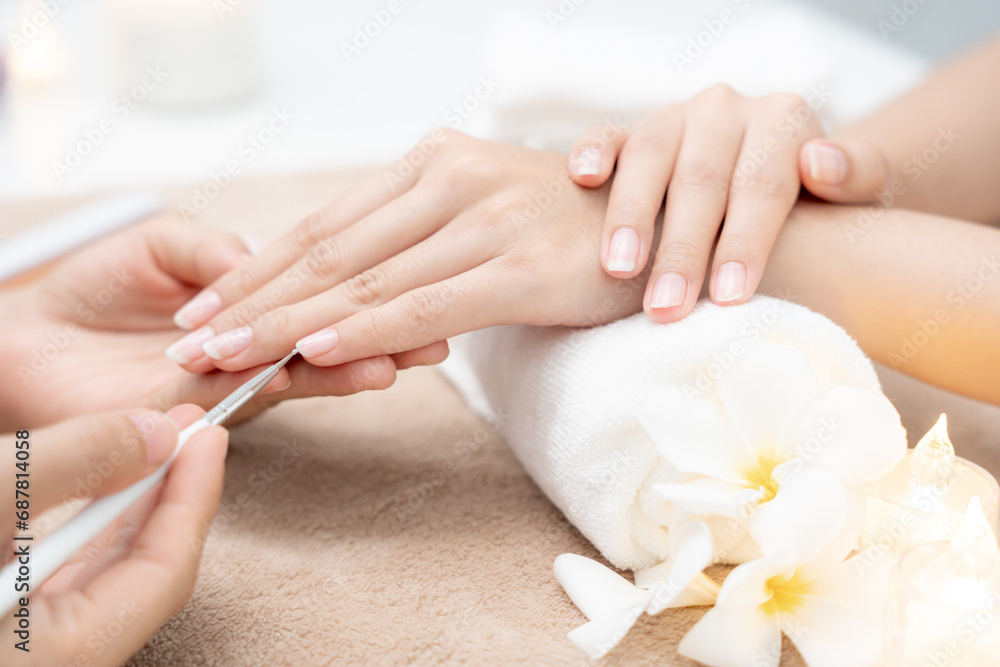 Naklejka premium Woman receive care service by professional Beautician Manicure at spa centre. Nail beauty salon use nail file for Glazing treatment. manicurist make nail customer to beautiful. body care spa treatment