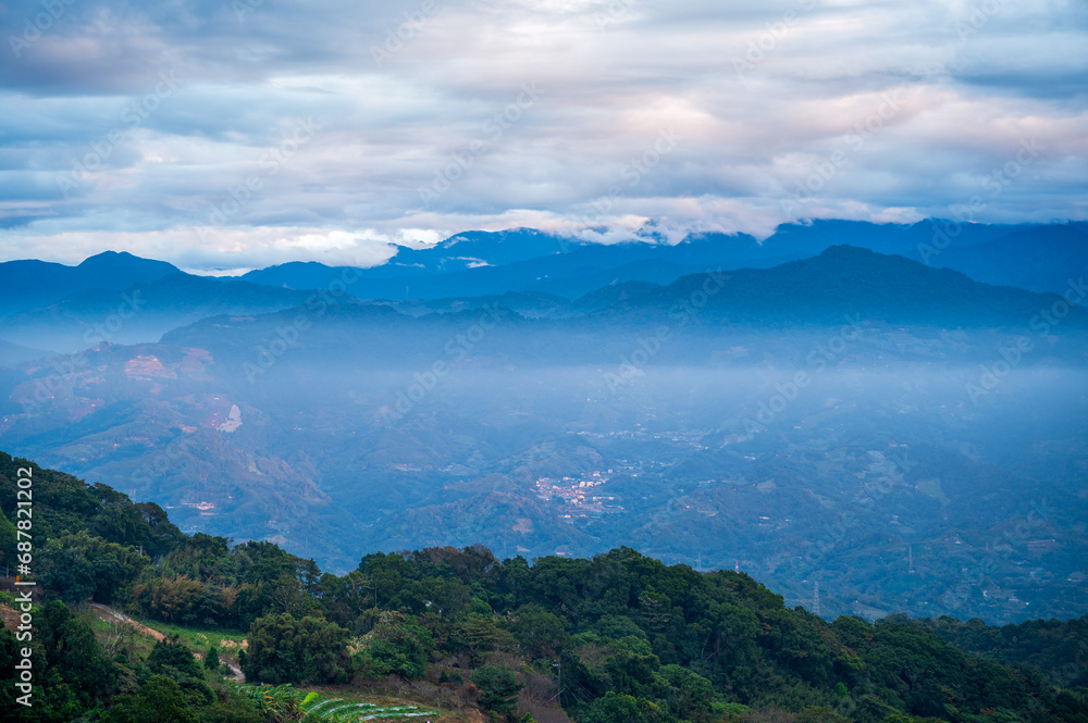 There are layers of white clouds floating over the valley villages. Ginger Garden Agritourism Area, Miaoli County, Taiwan.
