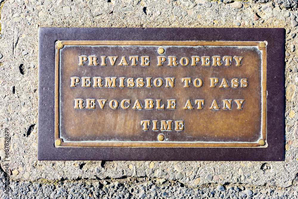 Private property sign with permission to pass revocable at any time