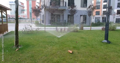 Automatic Sprinkler Watering Lush Green Grass in a Sprawling Field photo