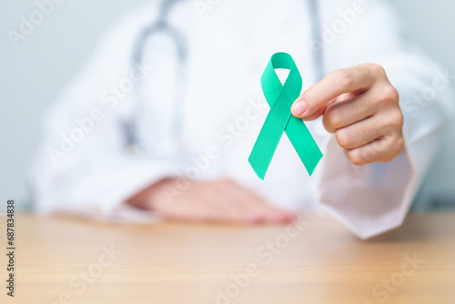 Doctor holding Teal Ribbon for January Cervical Cancer Awareness month. Uterus and Ovaries, Cervix, Endometriosis, Hysterectomy, Uterine fibroids, Reproductive, Healthcare and World cancer day photo