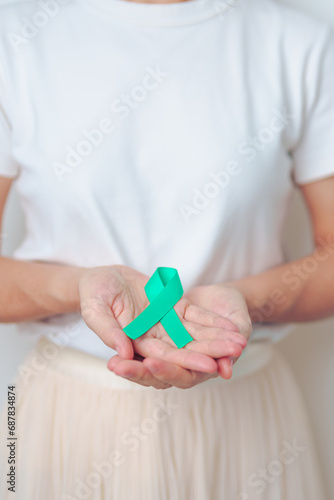 woman holding Teal Ribbon for January Cervical Cancer Awareness month. Uterus and Ovaries, Cervix, Endometriosis, Hysterectomy, Uterine fibroids, Reproductive, Healthcare and World cancer day