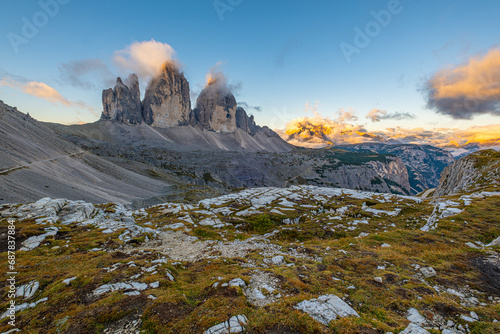 Golden hues adorn Tre Cime di Lavaredo at sunrise in the Dolomites, Italy. A captivating autumn scene, nature's masterpiece in radiant display