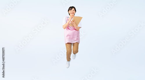 ジャンプするエプロンをつけた女性　保育士　介護福祉士　切り抜き全身写真（切り抜き背景透過PNGも販売しております。作成者リンクから「PNG」で検索してください） photo