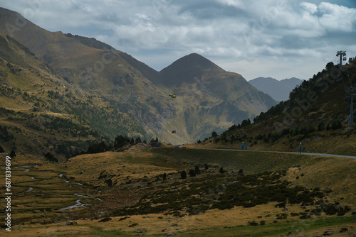 A helicopter transports cargo in the Pyrenees mountains for the construction of a difficult-to-access construction site.