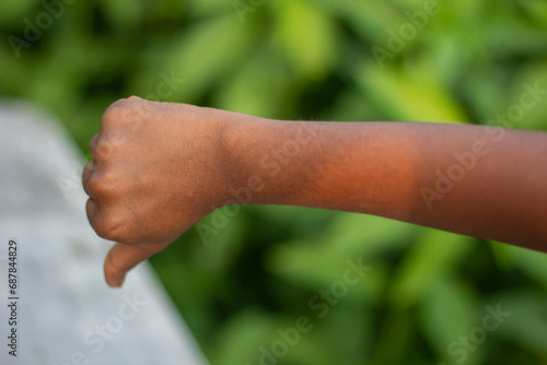 A man has his thumb pointing down and green background © Rokonuzzamnan