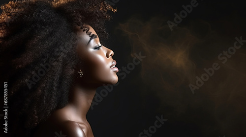 African American woman with curly hair in dark room, side view