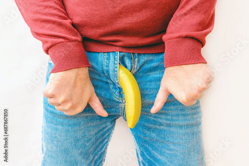 Potency problem concept.Mens denim pants with banana imitating male genitals.Hand shows thumbs down.Health and male sexuality concept.Closeup. photo