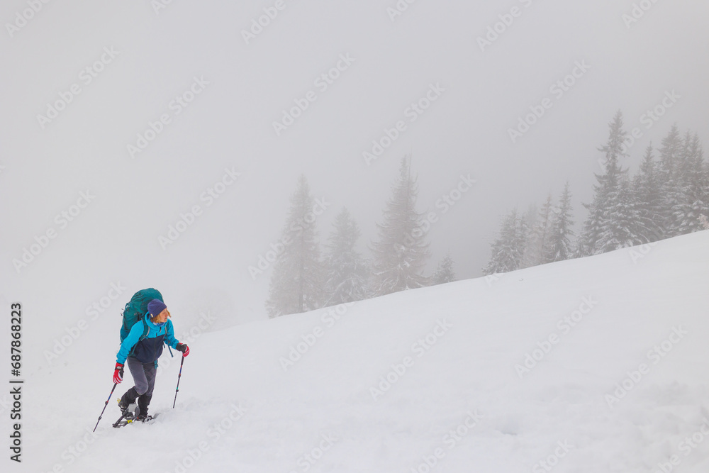 Climber in the mountains. A girl walks through the snow in the mountains.
