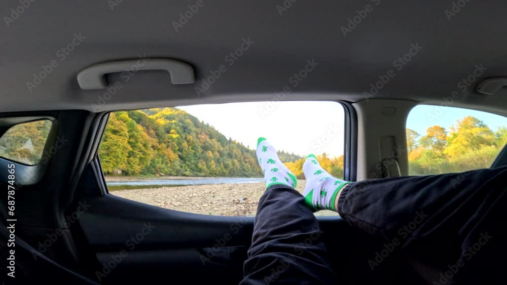 man stick out legs of car window man stick out legs of car window