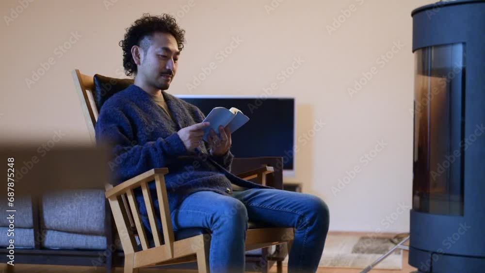 A man relaxes in an easy chair by the fireplace in his room A man relaxes in an easy chair by the fireplace in his room