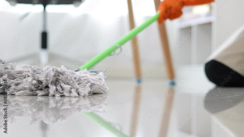 Cleaner is mopping floors at home with a mop. Cleaner is mopping floors at home with a mop.