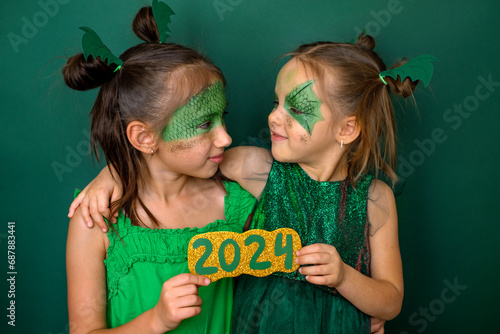 Children with painted faces hold the number 2024 on New Year's Eve. The made-up faces of children in the guise of a dragon are a symbol of the new year