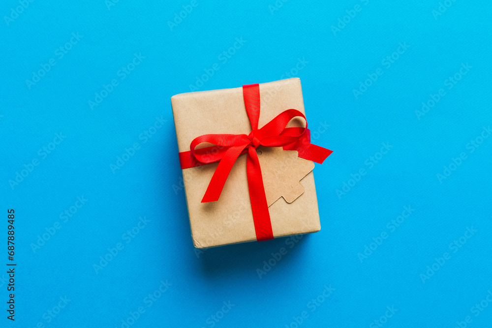 wrapped christmas or other holiday handmade present in paper with colored ribbon. Present box, decoration of gift on colourfull table, top view with copy space wrapped christmas or other holiday handmade present in paper with colored ribbon. Present box, decoration of gift on colourfull table, top view with copy space