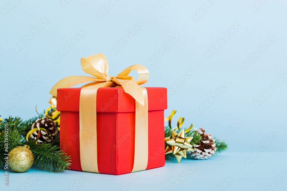 New Year Christmas mood, gift box, branches of a christmas tree, New Year decorations on a colored background