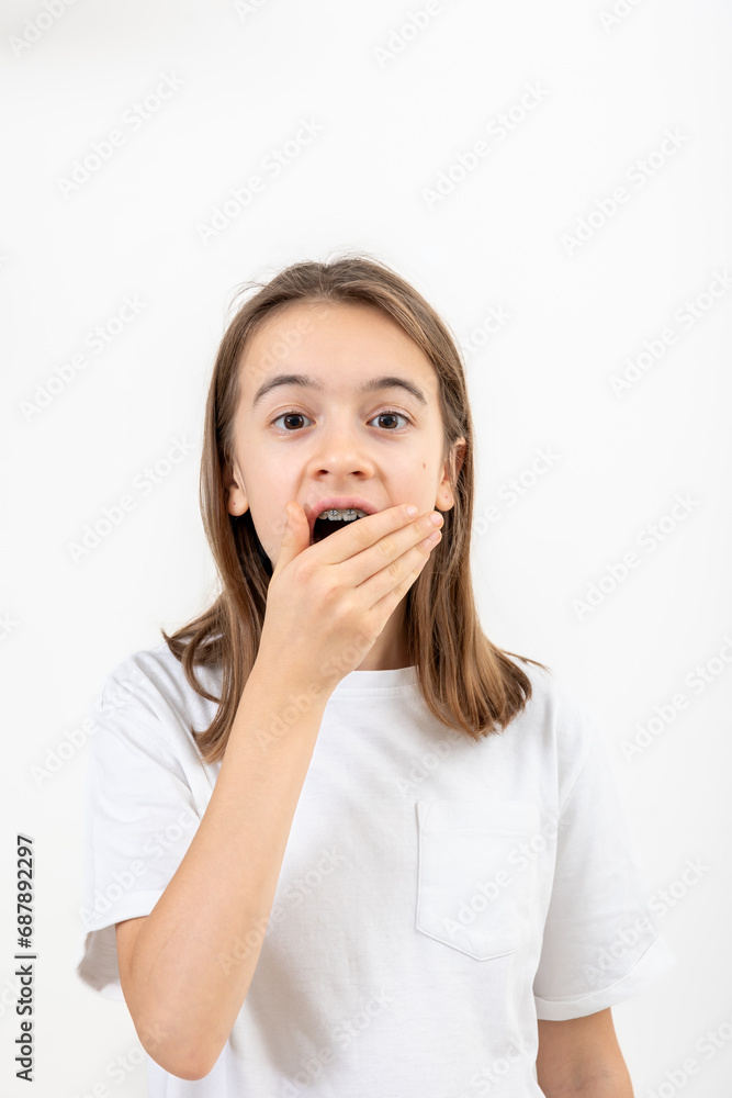Surprised teenage girl covering her mouth with her hand isolated on white. Surprised teenage girl covering her mouth with her hand isolated on white.