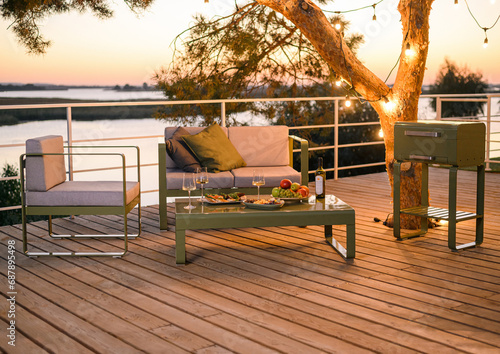 place to relax at sunset with a metal sofa and two armchairs with fabric cushions, a table with food