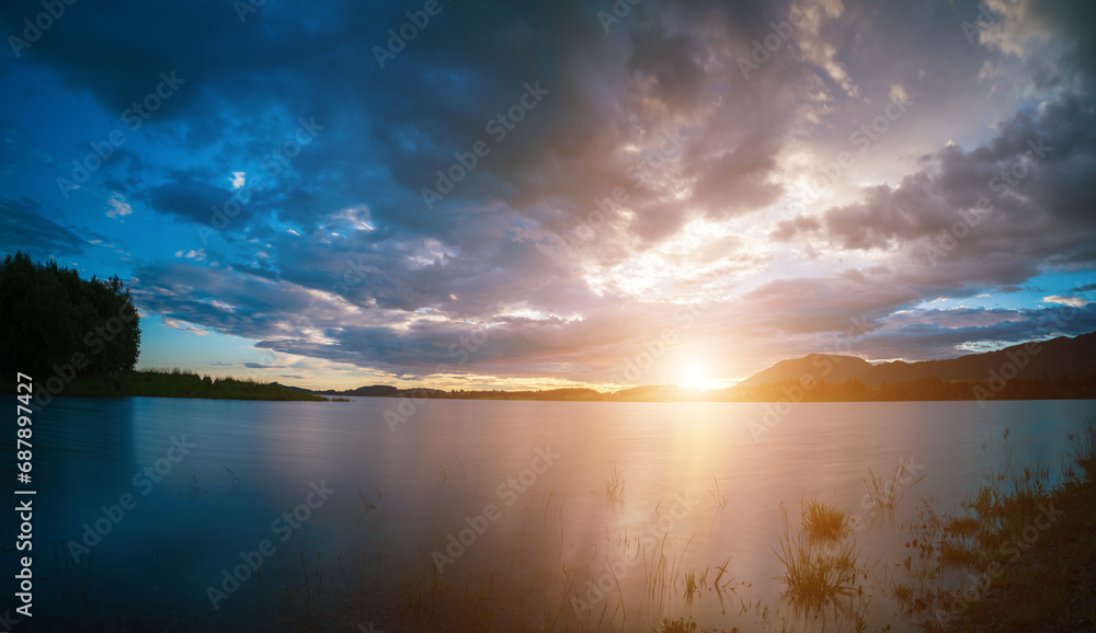 Tranquil mountain landscape with calm lake and dramatic sky