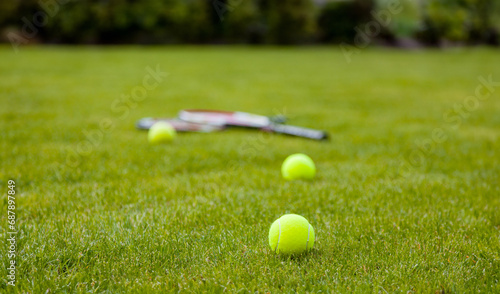 tennis balls and rackets on the green grass court