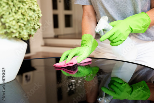 lose-up of a woman's hand wiping the coffee table at home