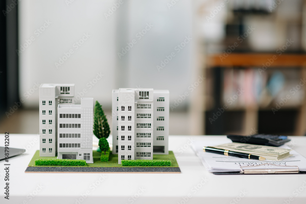 balancing the property sector The real estate agent is explaining the house style to see the house design and the purchase agreement.Wooden house balancing the property sector The real estate agent is explaining the house style to see the house design and the purchase agreement.Wooden house