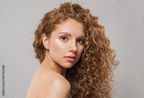 Young redhead model woman with long healthy wavy hairstyle, perfect clean fresh skin on white background, fashion beauty concept