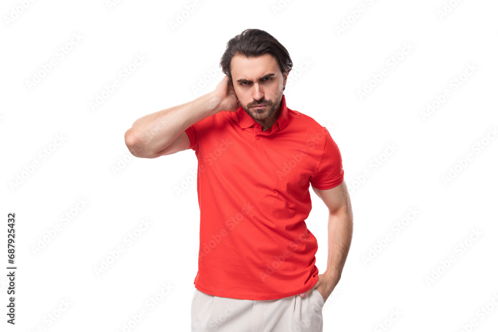 young handsome european brunette man with a beard dressed in a red t-shirt is brainstorming to solve a problem young handsome european brunette man with a beard dressed in a red t-shirt is brainstorming to solve a problem