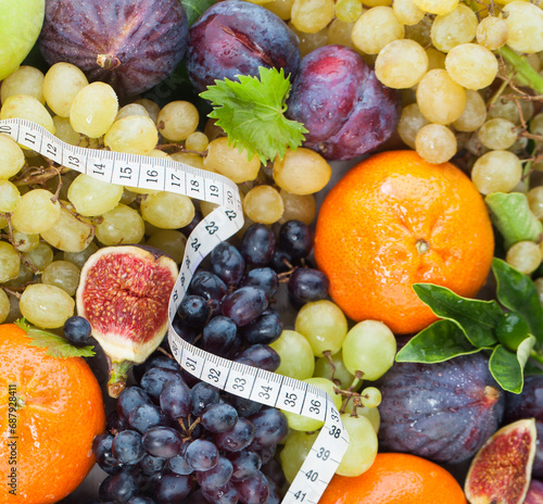 Fototapeta Naklejka Na Ścianę i Meble -  Measure tape on fruit. Healthy food background. Diet, nutrition and vitamin concept