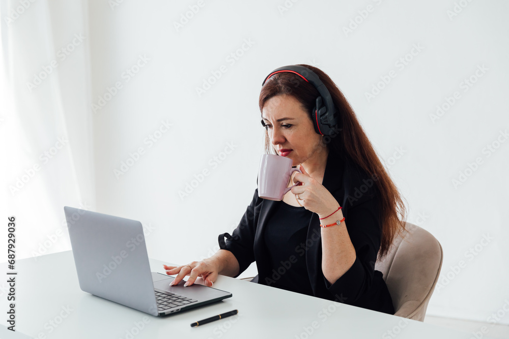 Business woman running online laptop in headphones Business woman running online laptop in headphones