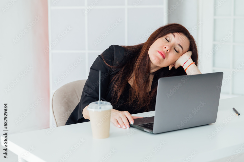 Tired business woman sleeping at desk at work in front of laptop Tired business woman sleeping at desk at work in front of laptop