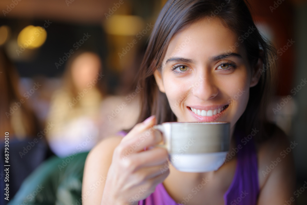 Happy restaurant customer looking at you with a coffee Happy restaurant customer looking at you with a coffee