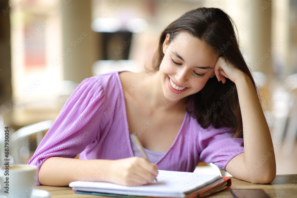 Happy student taking notes in a terrace Happy student taking notes in a terrace