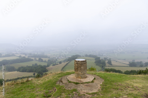 View from the Cotswold Edge between Stroud and Dursley the topographic marker on top of Coaley Peak along the Cotswolds Way with panoramic view over the hilly landscape of the Cotswolds, UK photo