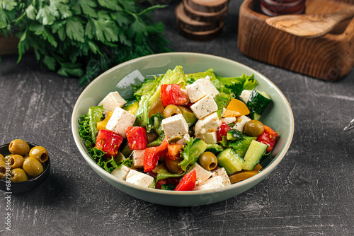 Portion of fresh greek salad on grey background