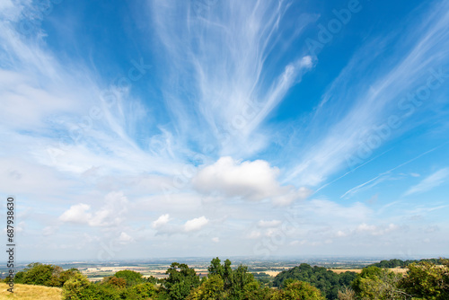 Panoramic view from one of the hills on the Cotswold Way just outside of Broadway, UK overlooking the landscape into the Malvern Hills Area with white clouds in blue sky photo