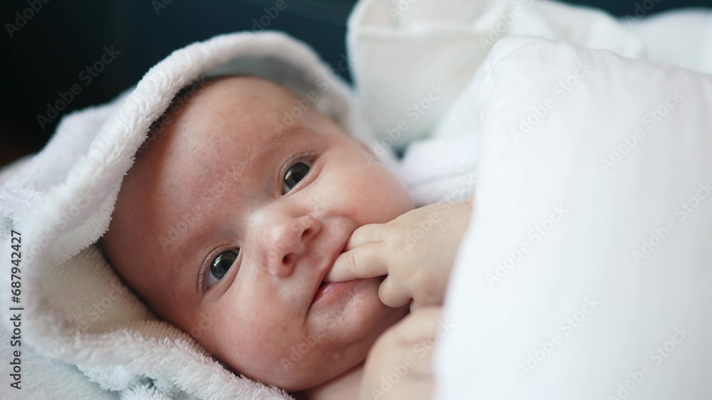 infant girl a newborn sucking thumb. happy family kid dream concept. close up cute newborn baby wrapped in bath towel at home indoors. daughter a small child lifestyle sucks his thumb after bathing infant girl a newborn sucking thumb. happy family kid dream concept. close up cute newborn baby wrapped in bath towel at home indoors. daughter a small child lifestyle sucks his thumb after bathing