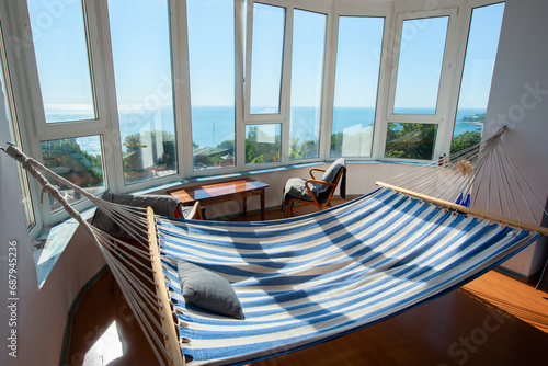 Vintage room on bay window with hammock  old fashioned armchair  retro radio table. Interior of 20th century  nostalgia. Summer vacation