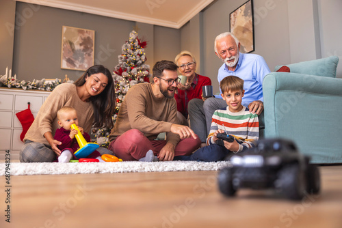Multi-generation family spending Christmas day together at home, adults playing with children
