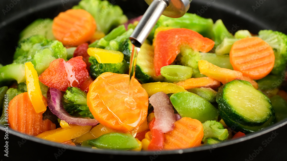 Pouring oil for cooking sliced vegetables in pan. Healthy food, vegetarian cuisine Pouring oil for cooking sliced vegetables in pan. Healthy food, vegetarian cuisine
