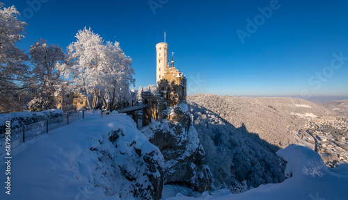 Winter wonderland panorama in Baden-Württemberg, southern Germany. Frosted trees with fairytale castle “Lichtenstein“ near Honau Reutlingen on a cold sunny december morning. Seasons greetings atmo.
