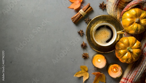 set the autumn mood with this top view photo of gilded cup of coffee with spices patchy scarf with pumpkin candles on grey backdrop make it a perfect composition for text or advert placement photo