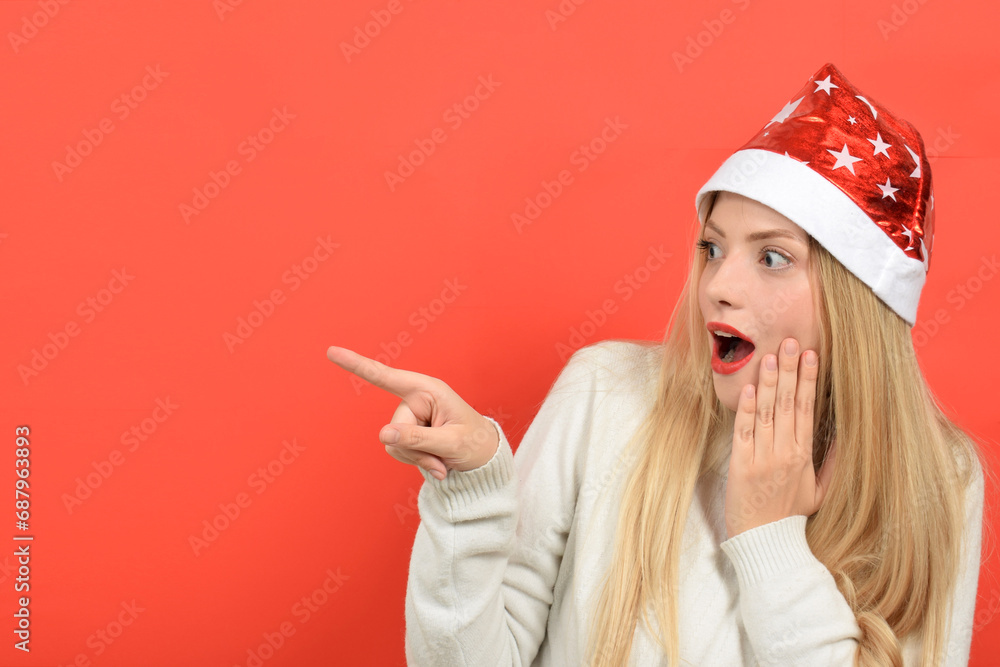 cute woman in santa hat pointing direction with finger cute woman in santa hat pointing direction with finger