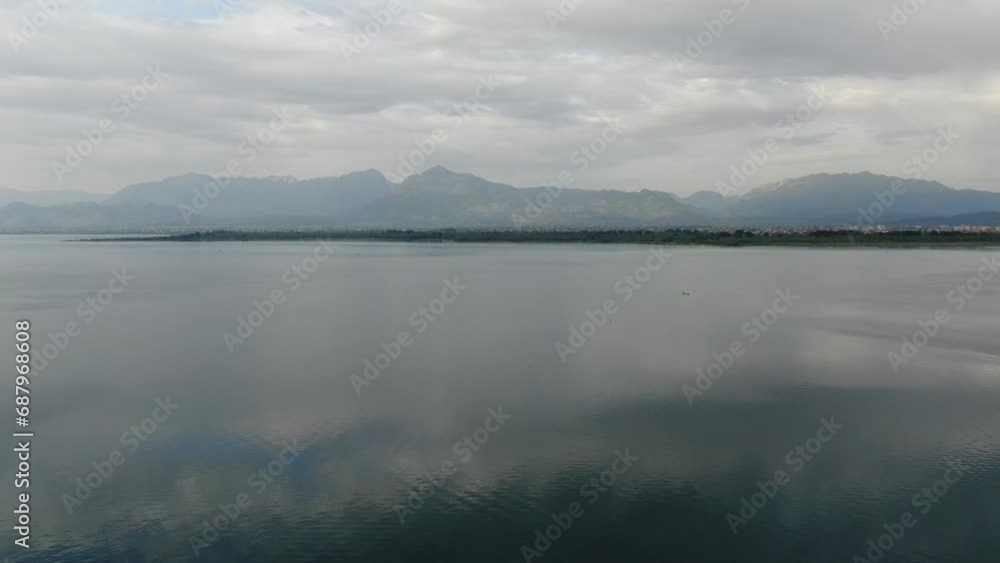 Drone view in Albania flying over Shkodër lake in Pogradec on cloudy day with mountains in the horizon Drone view in Albania flying over Shkodër lake in Pogradec on cloudy day with mountains in the horizon