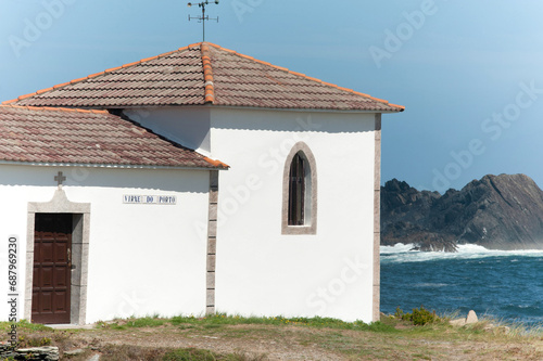 A small chapel formed by a construction and a bell tower on the edge of the sea
