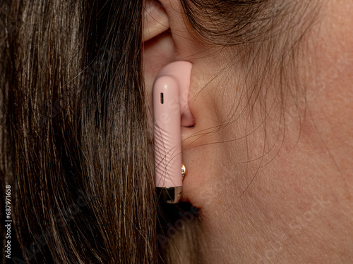 Close up shot of a person listening to music with an earpiece in his ear