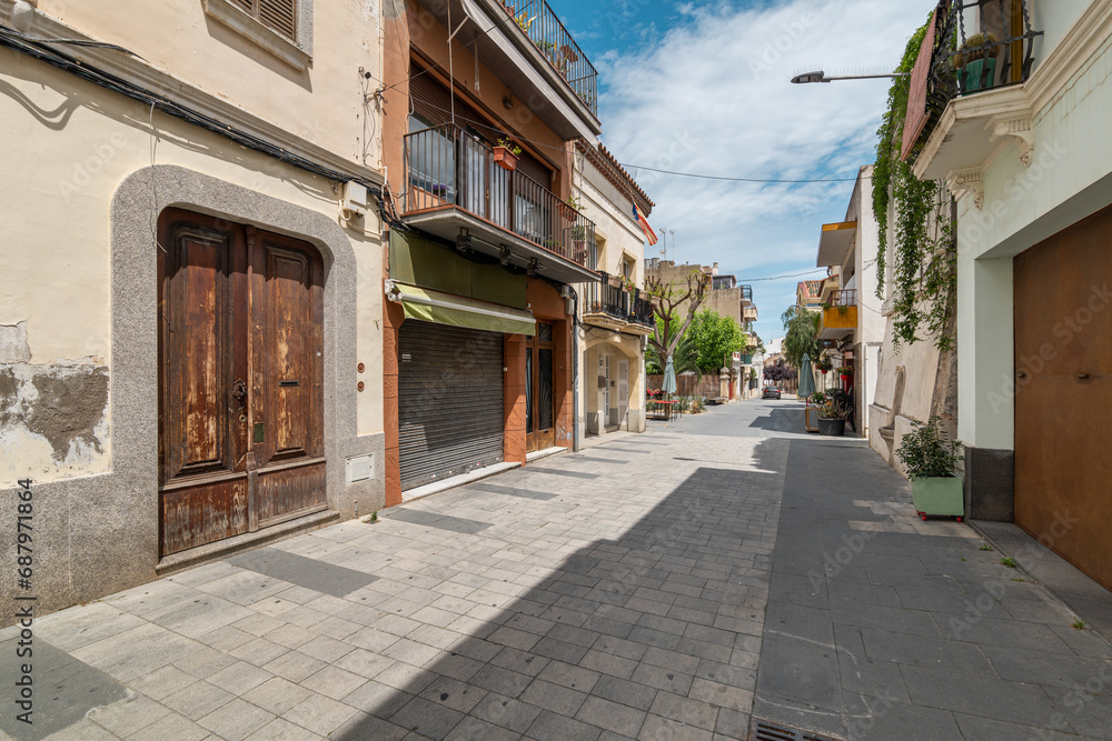 Narrow paved street with old buildings in Vilassar de Mar