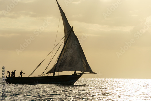 dhow traditional sailing vesssels of zanzibar tanzania at dusk viewed on a calm dusk evening
 photo
