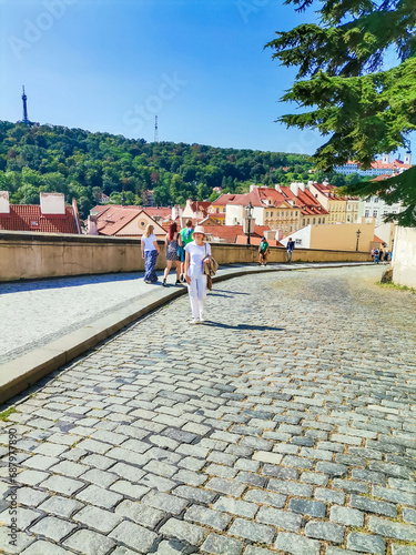 girl in a white staying in front in Prague. Looking at the beautiful blue sky