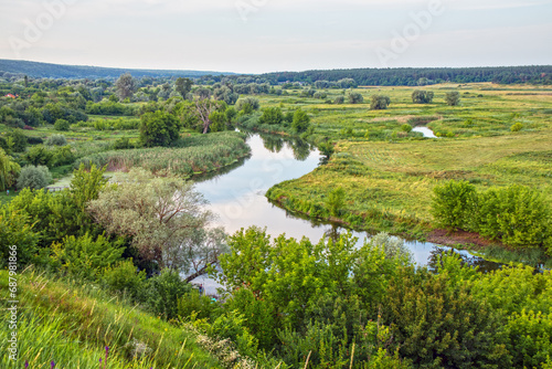 Picturesque landscape of the Seversky Donets river valley with meadow and trees in the countryside. View from the hill to the Siversky Donets River