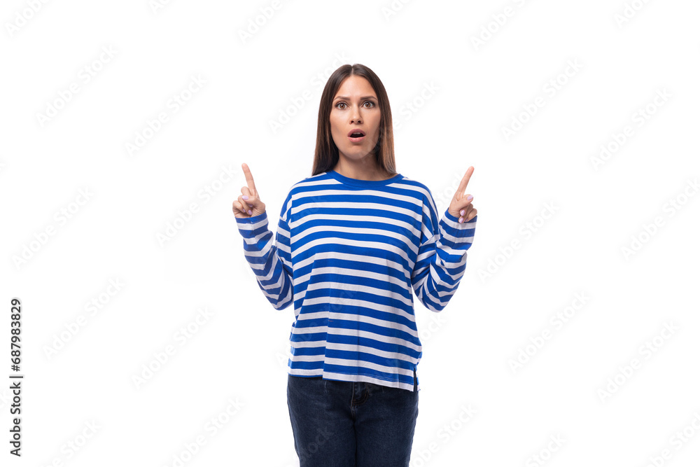 young european model woman wears a sweater with a sailor striped pattern points her hand to the side on a white background with copy space young european model woman wears a sweater with a sailor striped pattern points her hand to the side on a white background with copy space